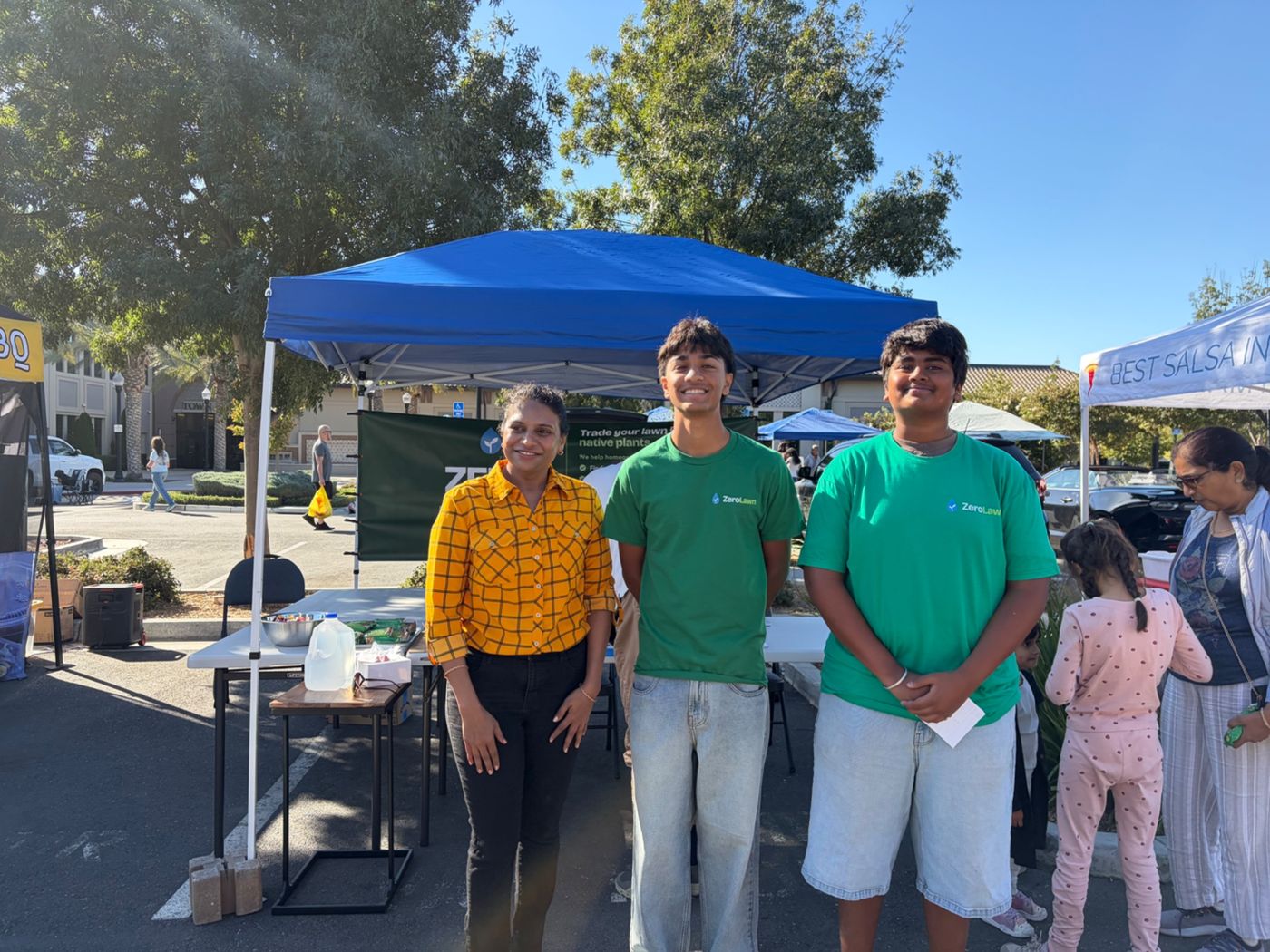 ZeroLawn students at their booth in front of the Trade your lawn for native plants banner