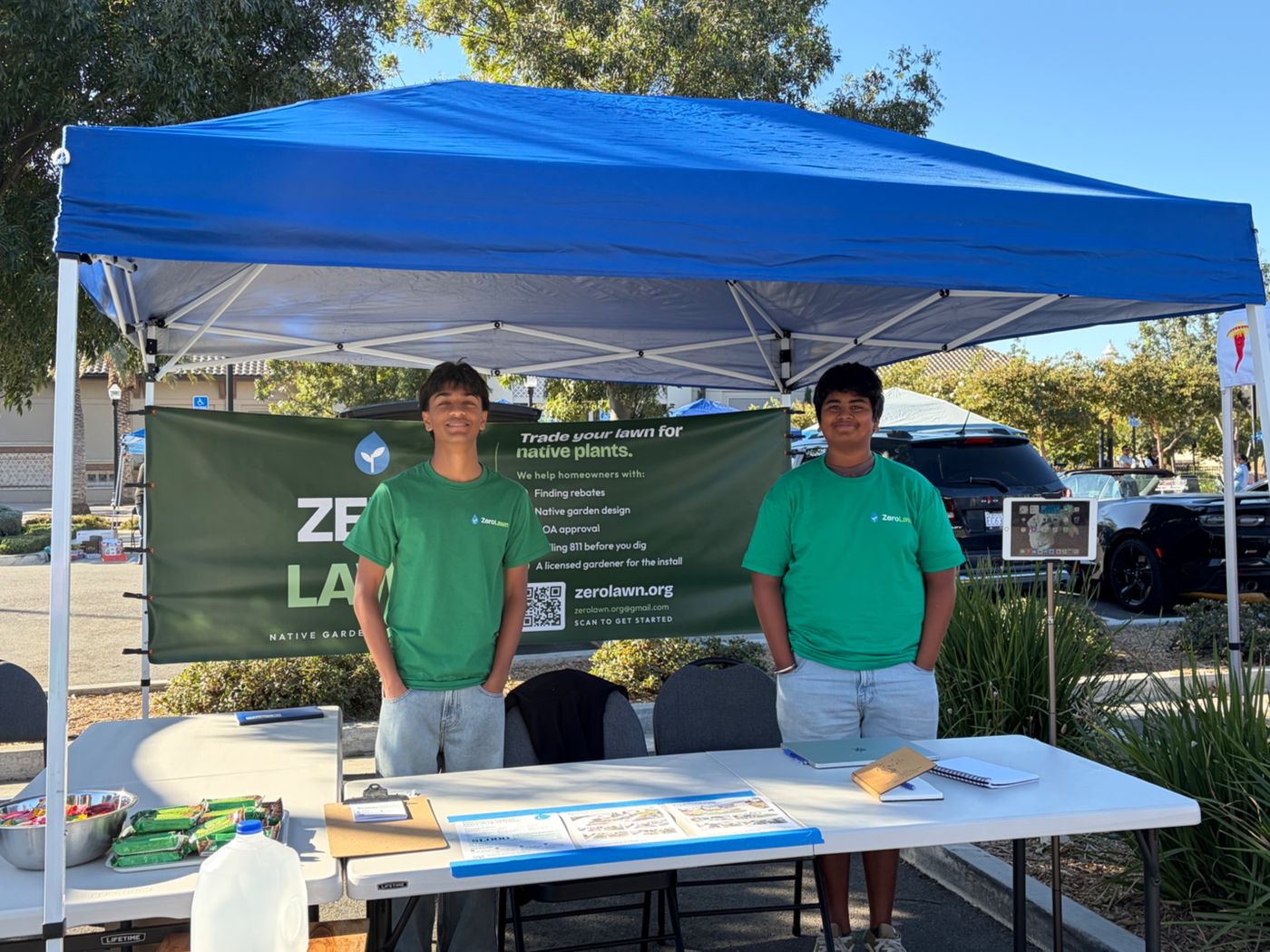 A neighbor visiting the ZeroLawn booth with two student volunteers